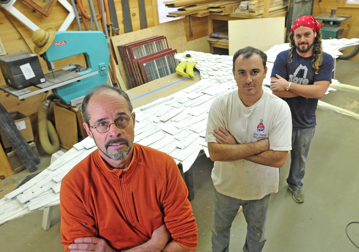 Stephen Dionne, left, with his employees Joe Almand, 33, center, and Dylan Daigle, 28, stand next to the 25-foot wooden seagull sculpture created by Skowhegan artist Bernard Langlais that they have restored.