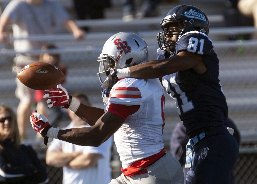Maine receiver Jordan Dunn has his hands full in keeping Stony Brook defensive back Winston Longdon from intercepting a pass in the first half Saturday at Orono.