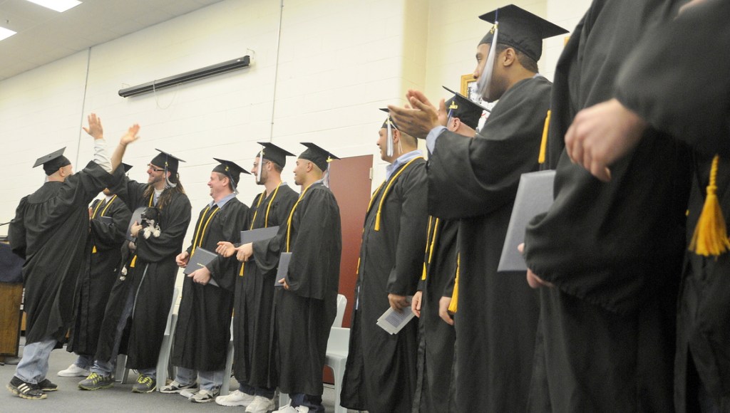 Maine State Prison inmates congratulate each other Monday after receiving diplomas at the Warren prison from the University of Maine at Augusta.