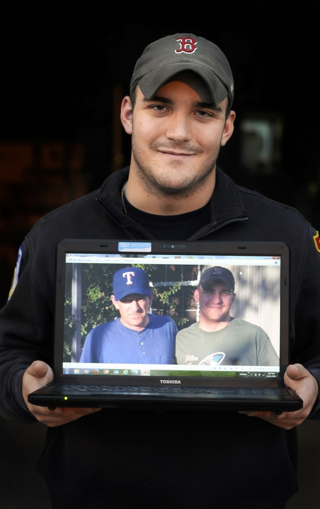 Zackery Spencer of Spencer, Mass., holds a photo of his father, Troy Spencer, and himself when they met for the first time, Oct. 5, in Texas. While their relationship needs work, his other kin have embraced him.