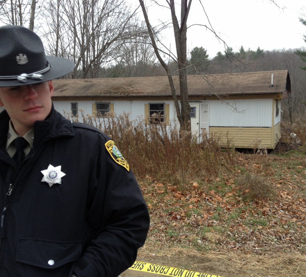 Sheriff’s Deputy Aaron Moody guards a mobile home in Vassalboro on Friday after the body of a Waterville man was found outside it. Police do not know if the man died there.
