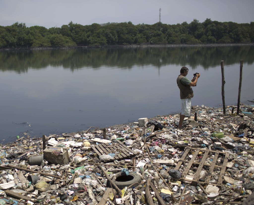 Biologist Mario Moscatelli takes photos of trash floating on the Canal do Fundao in Rio de Janeiro, Brazil, last month. Runoff from Rio’s many slums and poor neighborhoods drain into waters soon to host some of the world’s best athletes.