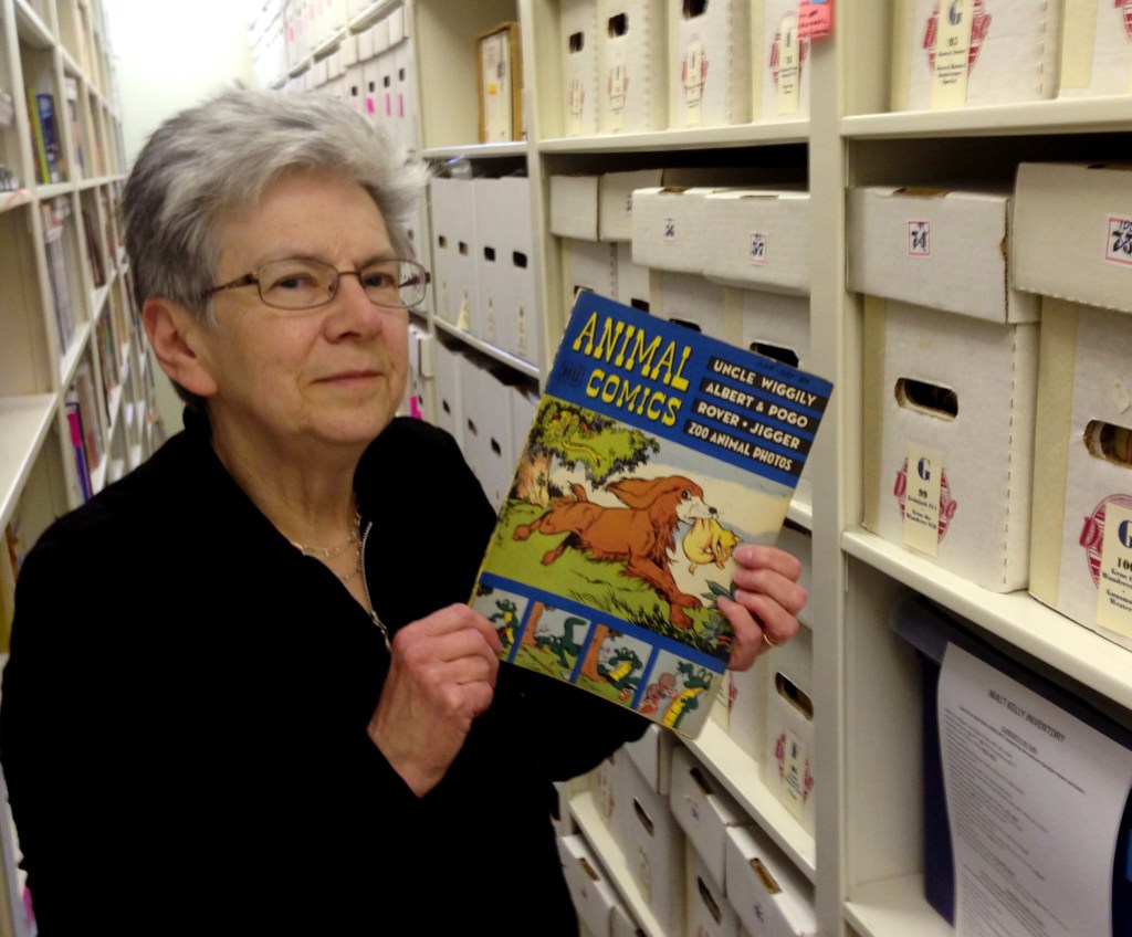 Maggie Thompson shows off a copy of “Animal Comics” in the addition built onto her Wisconsin home to house her estimated tens of thousands of comic books.