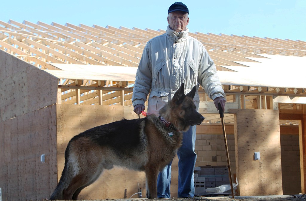 Lyman Pope poses with his dog Maximilian outside the construction site of the new SPCA animal shelter in Concord, N.H. Pope, 85, and retired has been spending thousands of dollars in Maine, New Hampshire and Vermont.