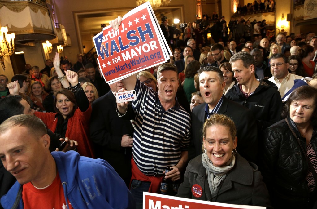 Martin Davis, of Weymouth, Mass., center, a Martin Walsh supporter, holds a placard while reacting to televised returns in the race for mayor of Boston during a watch party at a hotel in Boston, Tuesday, Nov. 5, 2013. Mass. State Rep. Martin†Walsh, D-Boston, and City Councilor John Connolly are running for the office held by Boston Mayor Thomas Menino for more than two decades.