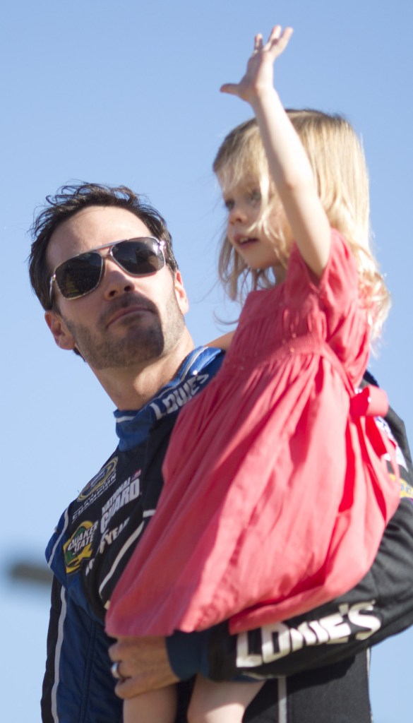 Jimmie Johnson holds his daughter, Genevieve, during driver introductions before the Sprint Cup season finale in Homestead, Fla. Johnson secured the championship with a ninth-place finish.