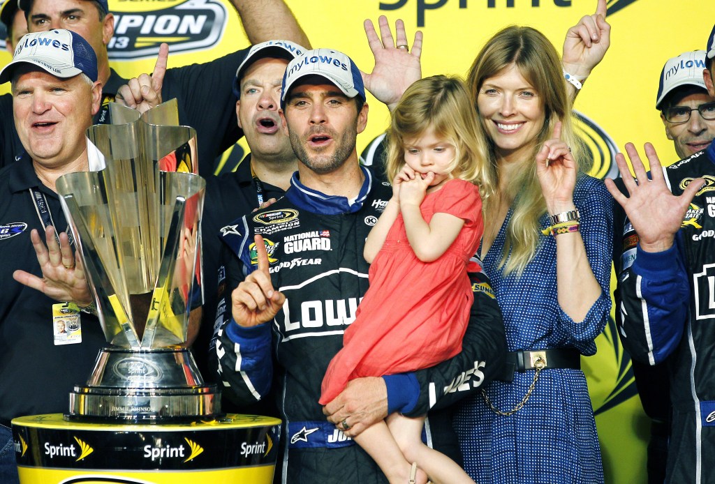 Jimmie Johnson, center, his wife, Chandra, and his daughter, Genevieve, celebrate after he won his sixth NASCAR Sprint Cup Series championship in Homestead, Fla., Sunday.