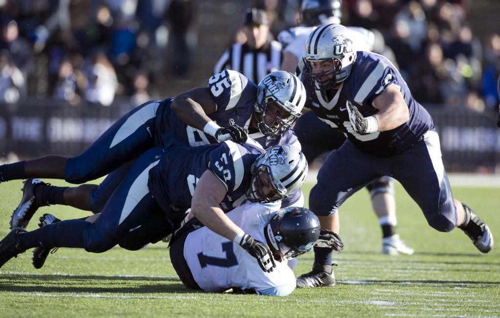 Maine quarterback Marcus Wasilewski (7) gets sacked by New Hampshire’s Sean McCann (58), Jay Colbert (55) and Matt Kaplan (60) in the second half of an NCAA.