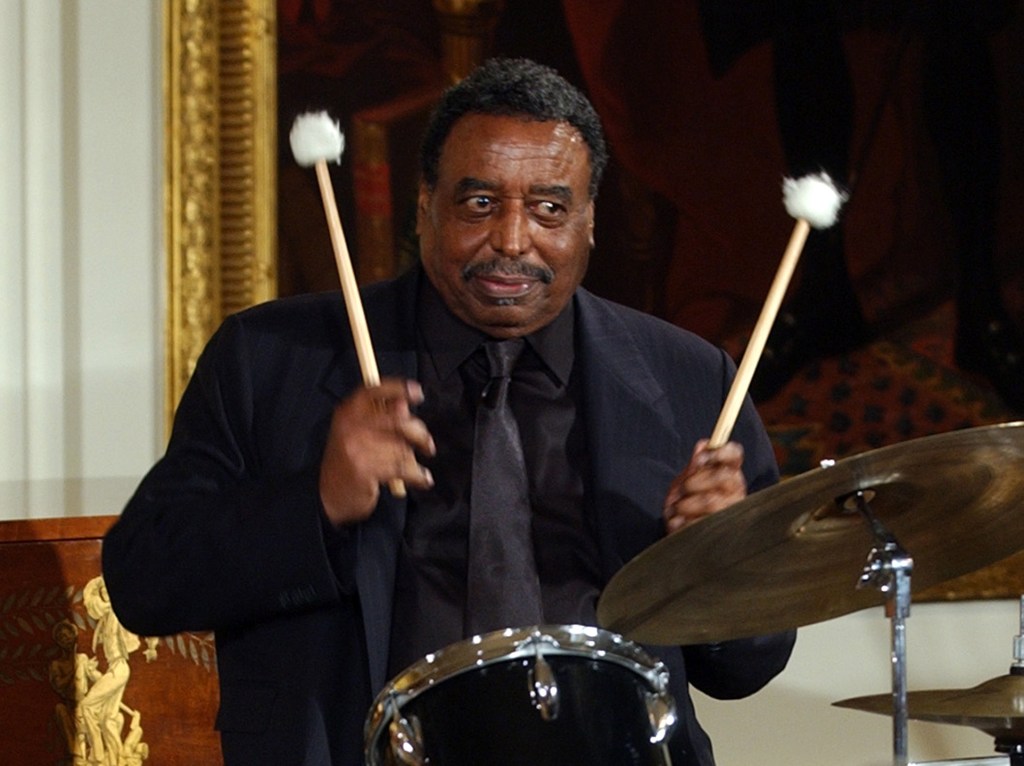 This 2004 photo shows Chico Hamilton, a recipient of the National Endowment for the Arts Jazz Masters Fellowship, performing a drum solo in the East Room of the White House during a reception to honor Black Music Month.