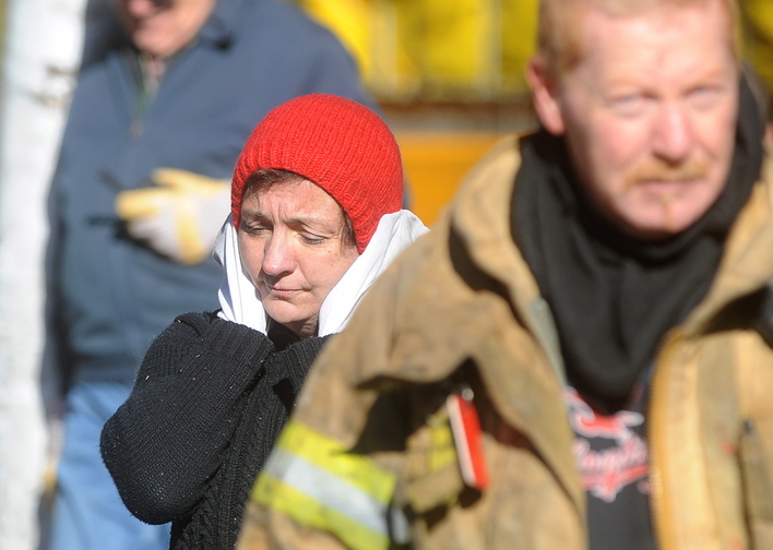 Laura Ellis reacts after she escaped injury when her car caught fire and spread to the trailer she was staying in on Beach Road in South China on Tuesday morning.