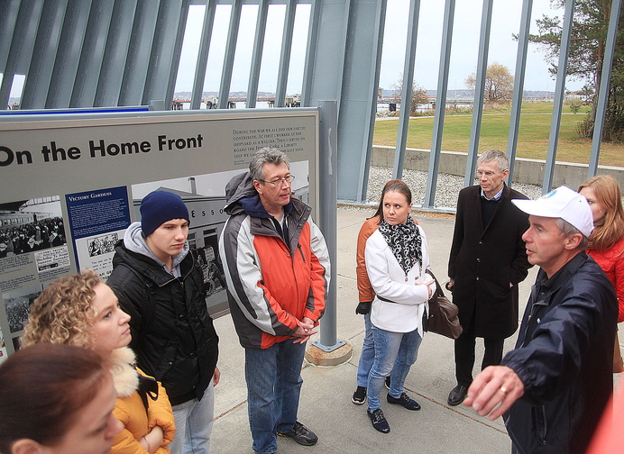 Andrei Strukov, center, an interpreter from Fairfield, listens with a Russian delegation from Portland’s sister city of Archangel as Portland City Councilor Ed Suslovic, far right, explains the history behind the Liberty Ship Memorial at Bug Light Park during a tour in South Portland on Sunday.