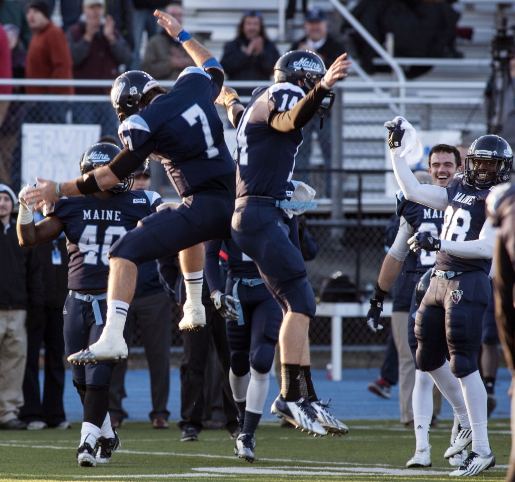 University of Maine quarterback Marcus Wasilewski (7) and teammate Daniel Collins (14) celebrate after defeating Rhode Island 41-0 in an NCAA football game in Orono on Nov. 16. Their team now holds a 10-1 record. Their success has caused “a nice little bit of unity” on campus, a student says.
