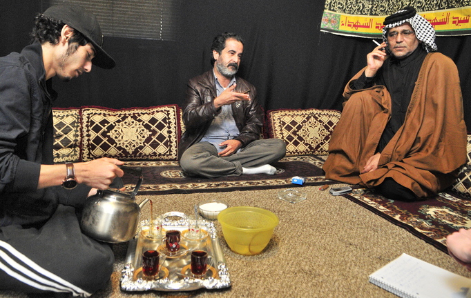 Youssof Zamat, left, pours tea while Ghazi Yousif, center, answers questions during an interview at the apartment of Khalid Zamat, right, in Augusta.