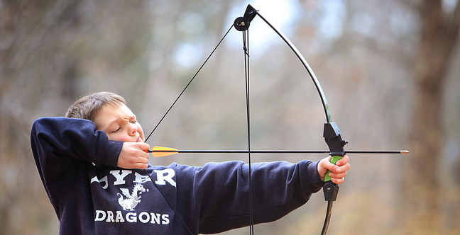 Emerson Dolan, 9, takes aim while practicing archery with his dad, Ryan, at their home in Cape Elizabeth.