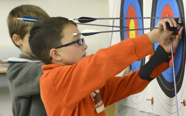Jonathan Dalessandro, 9, of Westbrook removes arrows from his target during practice at the Lakeside Archery shop in North Yarmouth.