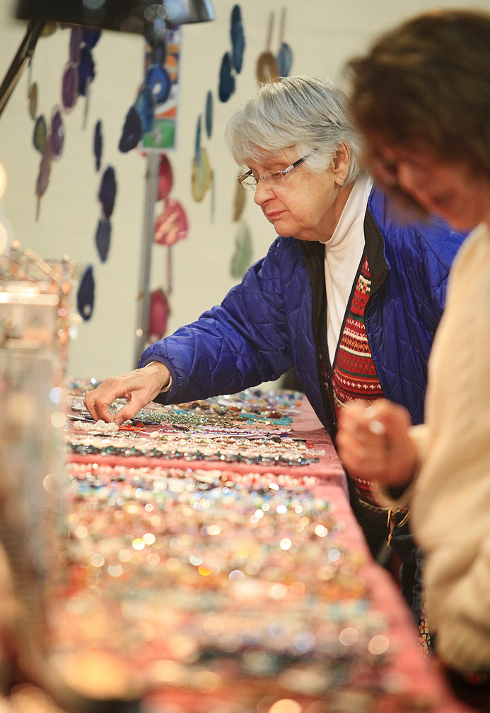 June O’Donnell of Gray looks at pieces of hand-crafted jewelry created by Crafty Scotts in Sabattus while shopping Sunday with friend Gailyn Doucette-Coons, also of Gray.