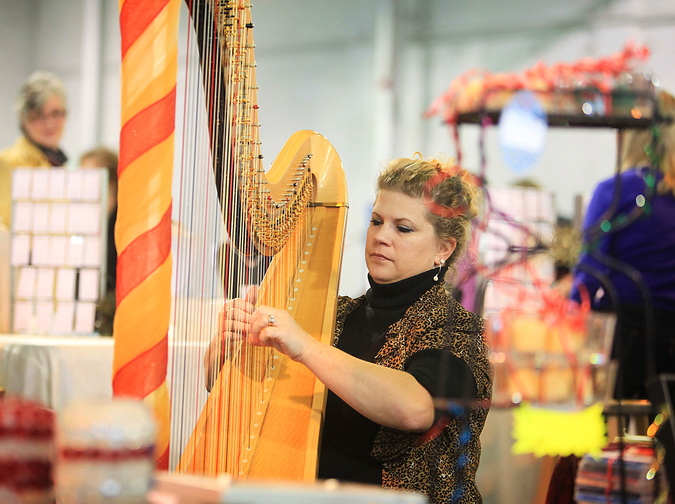 Mellori Worthen of Mercer, a professional orchestra and Celtic harpist, plays soothing holiday music on her harp for shoppers.
