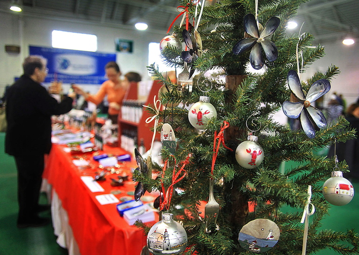 Handcrafted ornaments with Maine motifs, made by Tina Quattrucci of Saco, attract shoppers at a holiday craft fair at the Stevens Avenue Armory in Portland on Sunday.