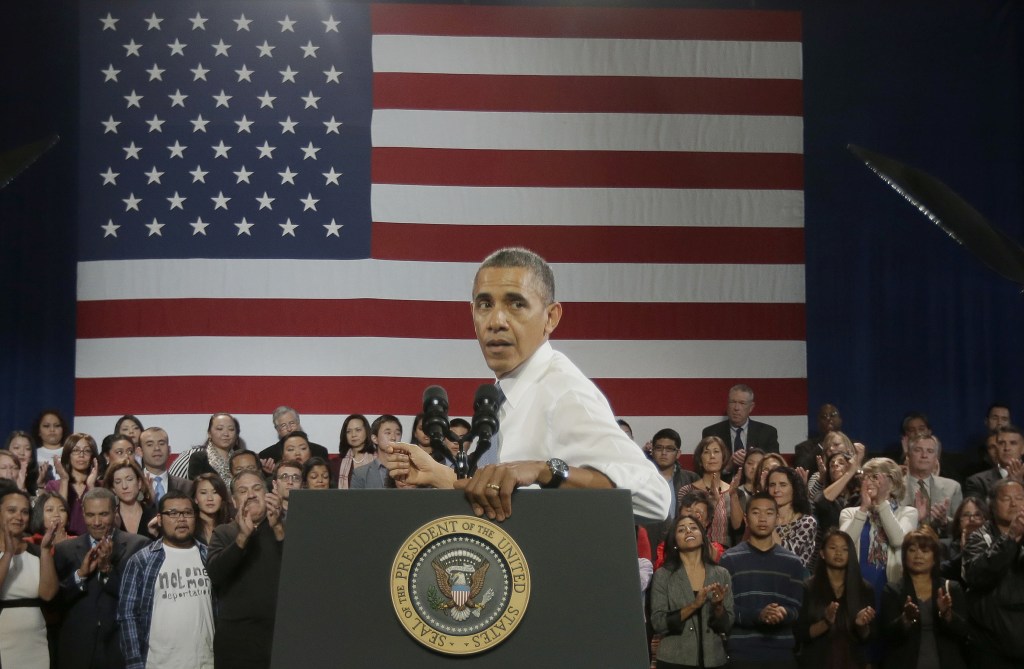 President Obama turns around to respond to a heckler interrupting his speech about immigration reform Monday in San Francisco. The heckler, who urged the president to stop deportations, was allowed to remain in the audience.