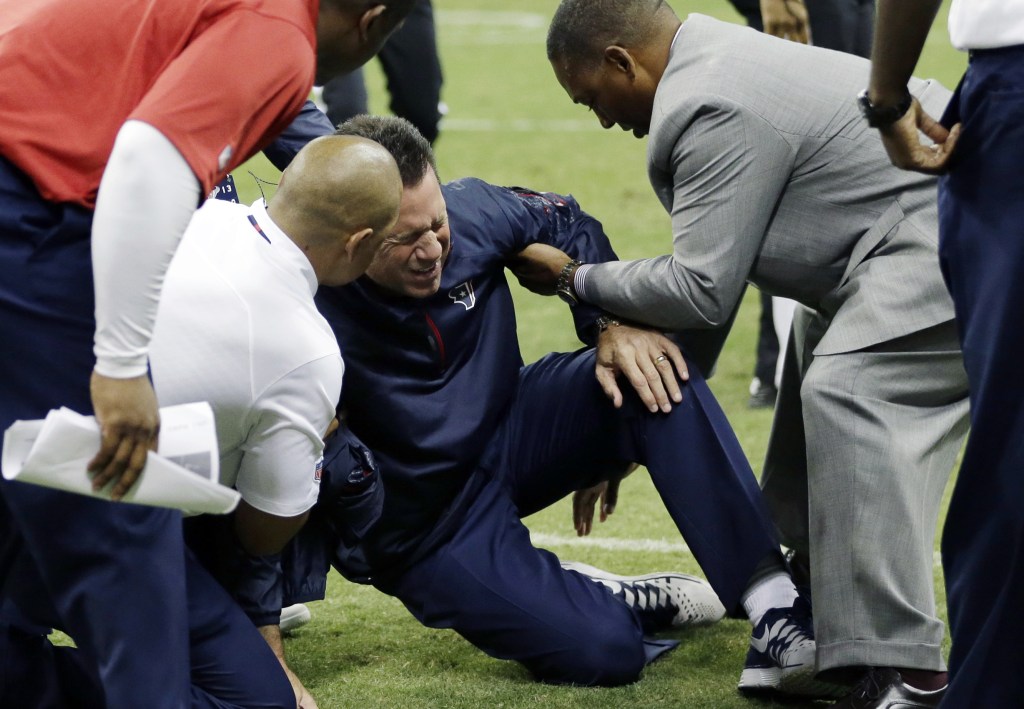 Houston Texans head coach Gary Kubiak, center, is helped after he collapsed on the field during the second quarter of a game against the Indianapolis Colts on Sunday in Houston.