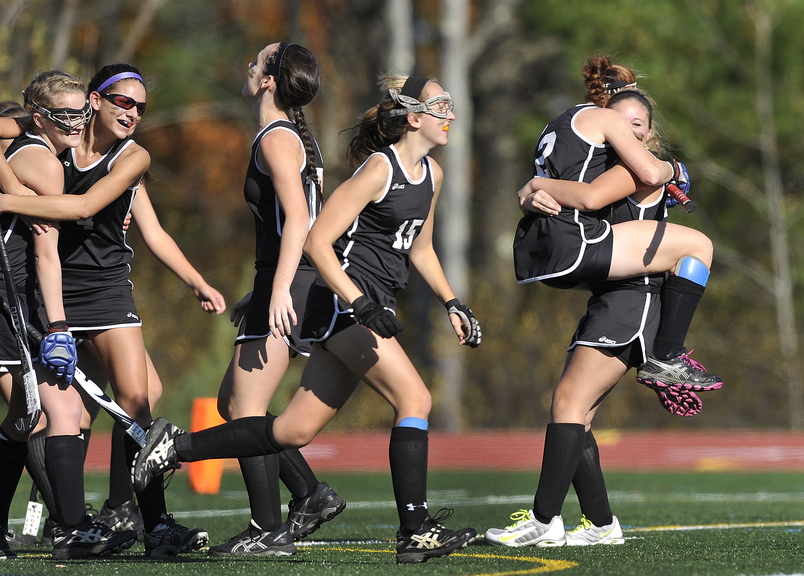 Skowhegan’s Renee Wright, (2) and Emily Trial, (23) embrace at far right as they celebrate their victory over Scarborough during the Class A field hockey championship at Yarmouth High School Saturday, November 2, 2013.