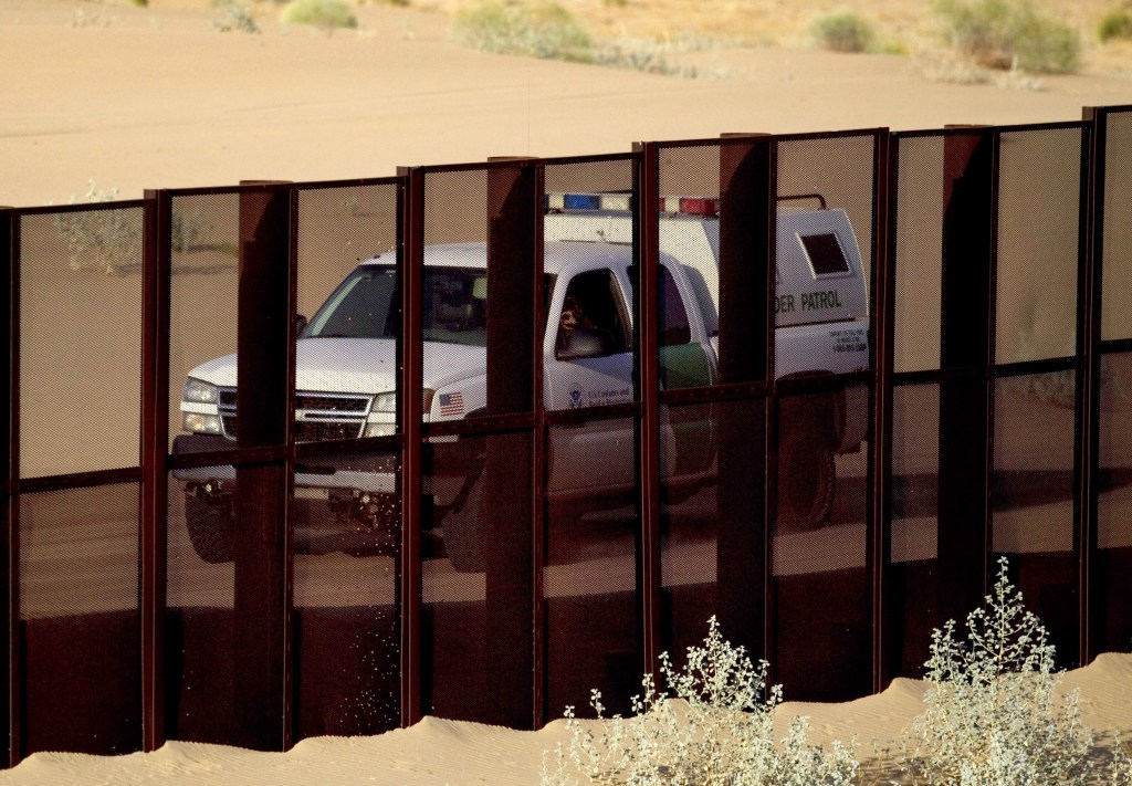 In this July 28, 2010, photo, a U.S. border patrol vehicle drives along the U.S.-Mexico border fence near Yuma, Ariz., as seen from the outskirts of San Luis Rio Colorado, Mexico.