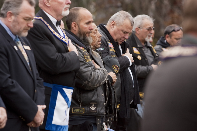 Attendants reflect in prayer during the second annual Veterans Day observance at Pine Grove Cemetery in West Kennebunk on Sunday.