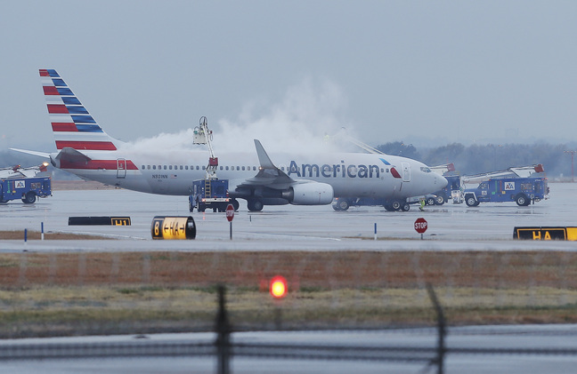 Crews spray deicing solution onto an American Airlines 737 before departure at Dallas-Fort Worth International Airport on Monday. Winter weather has affected hundreds of flights.