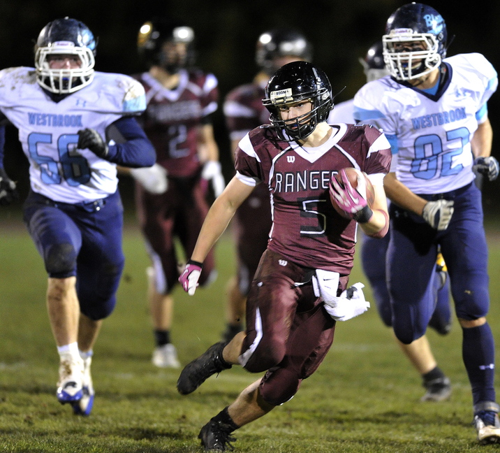 Greely's Sam Peck gets into the Westbrook secondary for some yardage as Westbrook's Alex Gauvin (66) and Noah Collins (82) give chase during first half action Friday night.