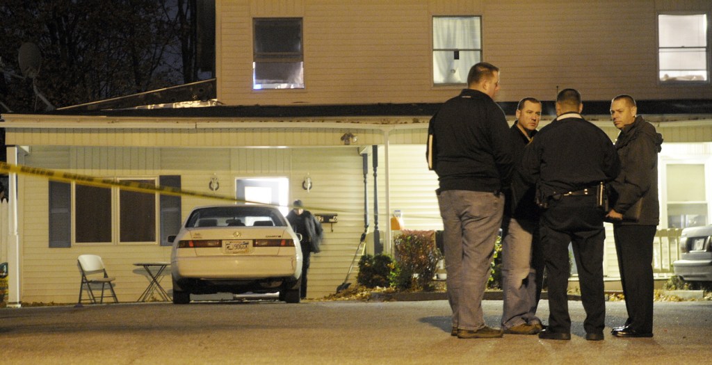 Augusta and state police detectives confer Wednesday evening outside an apartment at 32 Crosby St. in Augusta after a woman was found dead and a man wounded in the first-floor unit just after 8 p.m.