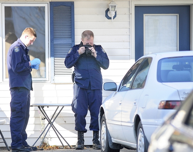 Investigators work at the scene of a homicide Thursday at 32 Crosby St. in Augusta.