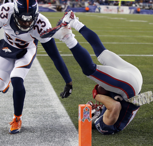 Patriots wide receiver Julian Edelman, right, lands in the end zone with one of his two touchdown catches Sunday night.