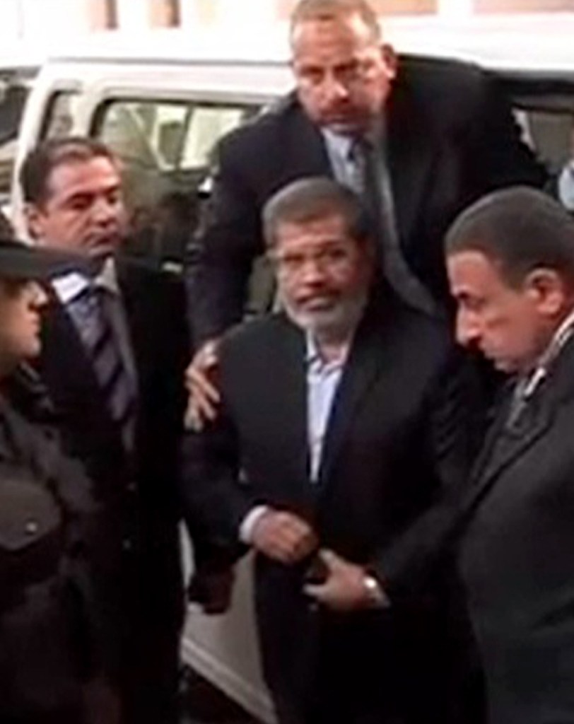 This image made from video provided by Egypt’s Interior Ministry shows ousted President Mohammed Morsi, center, arriving for a trial hearing in Cairo on Monday.