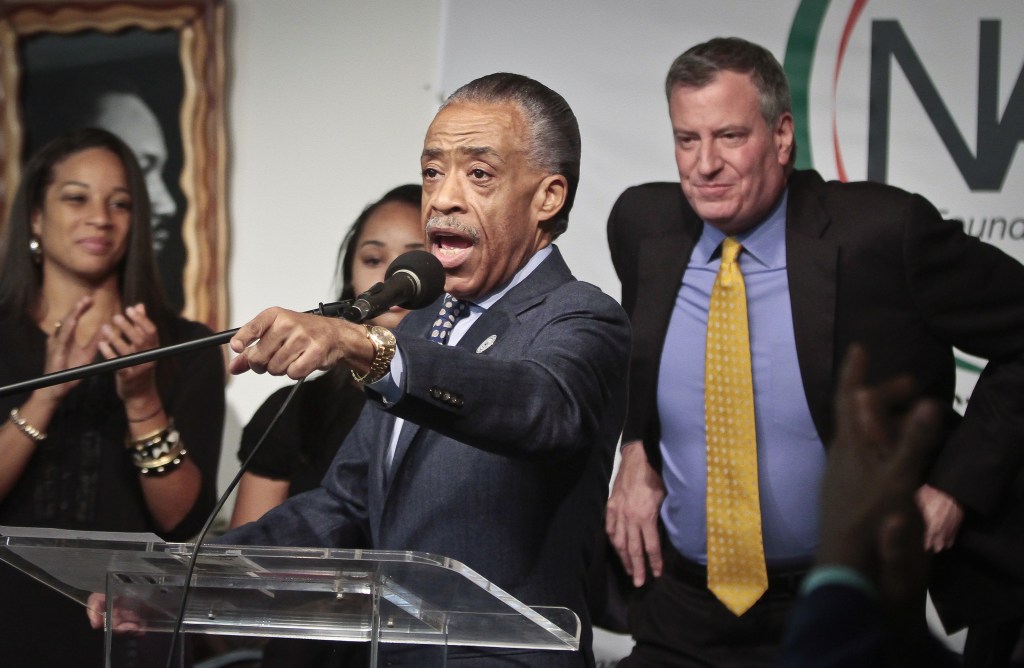 Rev. Al Sharpton, center, president of National Action Network, welcomes Mayor-elect Bill de Blasio, right, to the organization’s headquarters on Saturday, in New York. De Blasio thanked voters and outlined his vision for New York as mayor during a live radio broadcast.