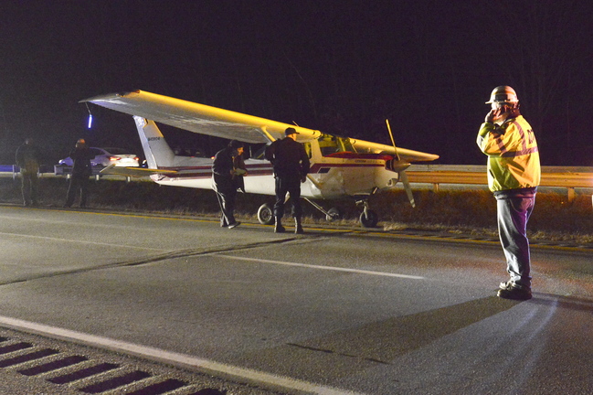 State police and state transportation officials inspect the small plane that made an emergency landing on I-295 Thursday.