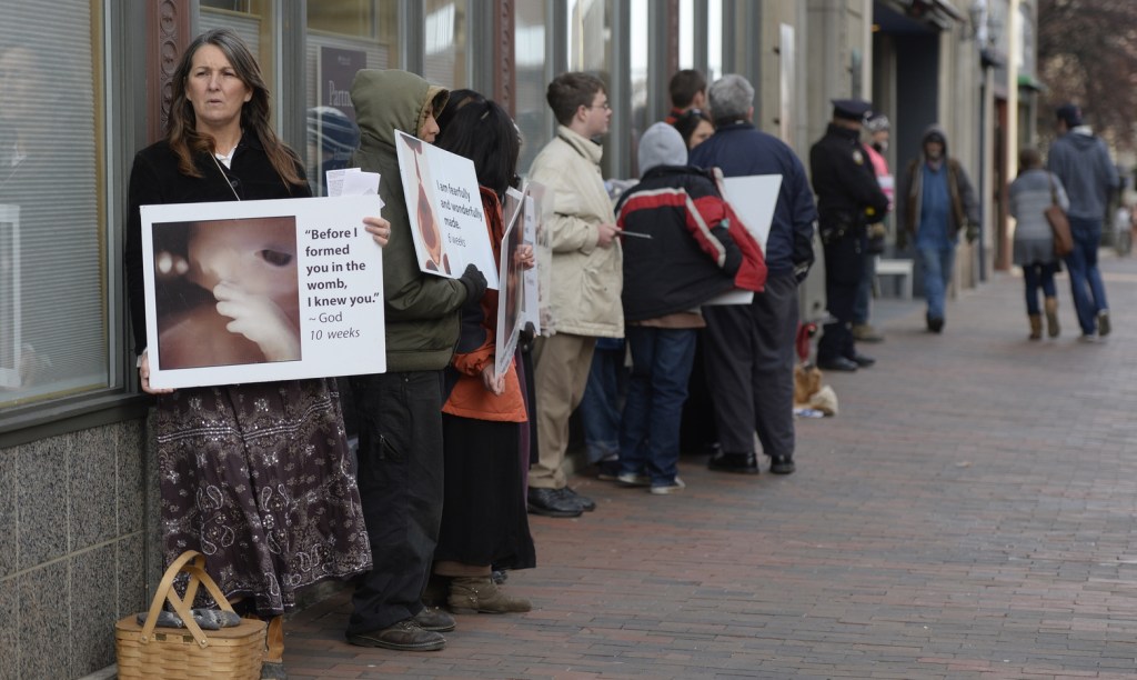 Leslie Sneddon of Richmond protests outside Planned Parenthood on Congress Street in Portland on Friday.
