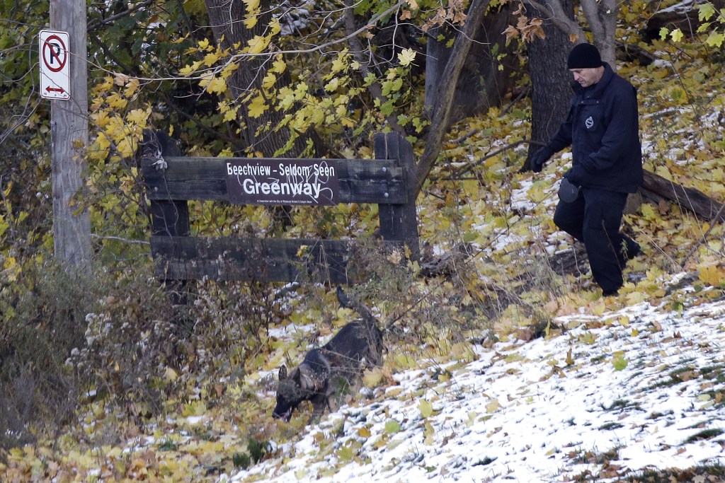 A Pittsburgh police K-9 officer comes out of the woods near the scene where three students were shot outside Brashear High School on Wednesday in Pittsburgh. Police were searching for at least one gunman in some nearby woods and the neighborhood surrounding the school, school and police officials said. Six people were brought in for questioning.