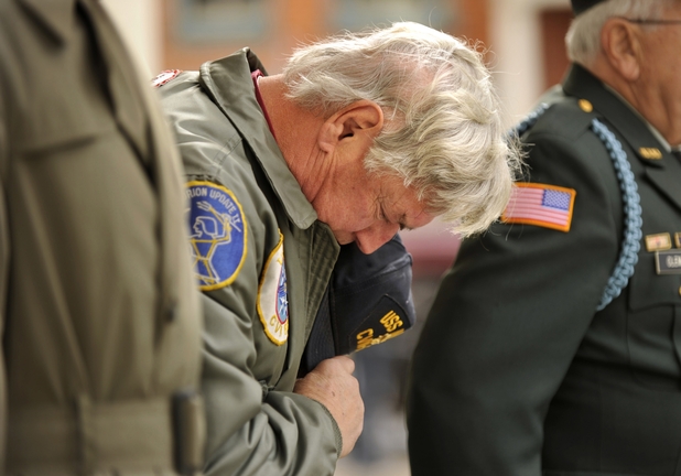 Michael Young of Bellefonte, Pa., a retired Navy lieutenant commander, bows his head Monday during a Veterans Day ceremony outside the Centre County Courthouse in Bellefonte. The federal Department of Veterans Affairs has set a 2015 deadline for eliminating the backlog of disability claims, but it has a long way to go to reach its goal.