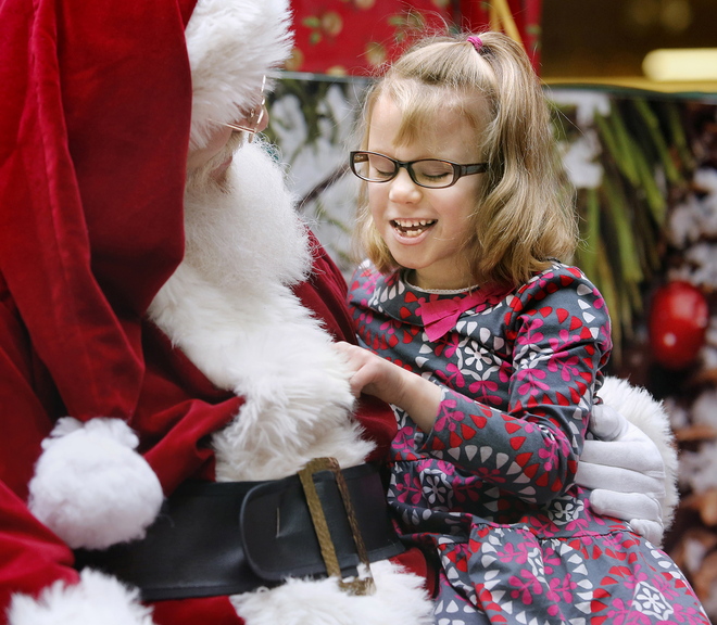 Isabella Sherman, 6, of Saco smiles as she visits with Santa on Sunday at the Maine Mall during a special experience for children with autism. Lights were dimmed and the traditional mall music shut off to limit distractions for the children and their families.