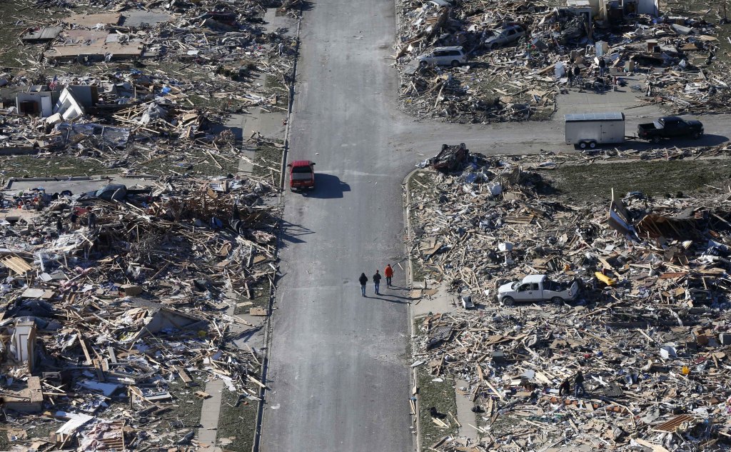 People walk down a street amid tornado devastatation Monday in the western Illinois town of Washington. It was one of the worst-hit areas after intense storms and tornadoes swept through Illinois on Sunday. The National Weather Service says the tornado that hit Washington had a preliminary rating of EF-4, meaning wind speeds of 170-190 mph.