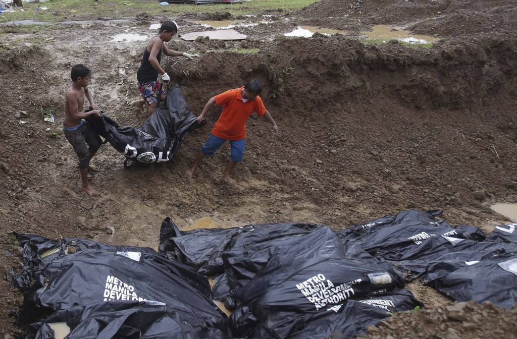 Filipino workers bring body bags to a mass burial site at Baspe public cemetery at typhoon-hit Tacloban, Leyte province, central Philippines on Thursday. Typhoon Haiyan, one of the most powerful storms on record, hit the country’s eastern seaboard last Friday, destroying tens of thousands of buildings and displacing hundreds of thousands of people.