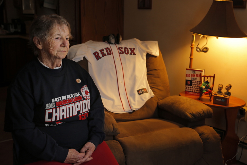 Patricia Kennedy sits in her living room Thursday next to where her late husband, James, often watched his beloved Red Sox play baseball. He died Tuesday, so the family placed the jersey there for Wednesday’s game.