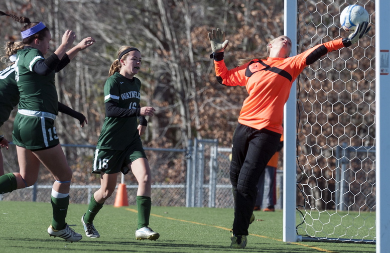 Orono keeper Victoria Goodwin tries to control Esme Benson’s shot in the second overtime Saturday, but as she fell the ball went over the line and Waynflete retained the Class C crown. In on the play are Ella Millard, left, and Leigh Fernandez.