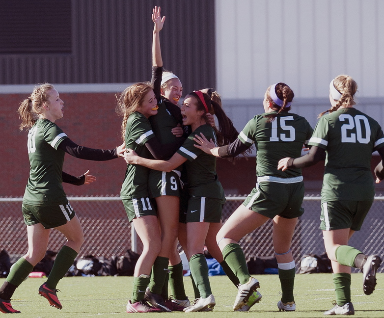 Esme Benson is mobbed by teammates Arianna Giguere (10), Christian Rowe (11), Sofia Canning; Ella Millard (15), and Cat Johnson (20). Benson scored in the second overtime to give Waynflete a 3-2 victory against Orono in the Class C state final.