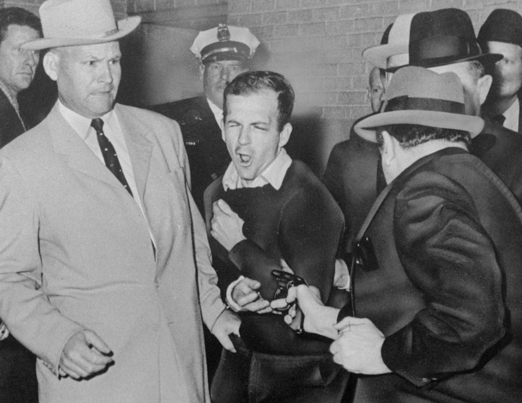 JFK assassin Lee Harvey Oswald, escorted by Detective James Leavelle, is shot in Dallas.