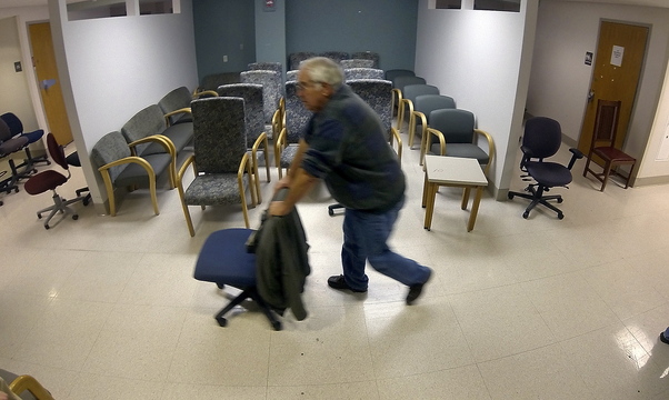 Mike Thomas of Monmouth rolls a desk chair down a hallway during the public sale of items Saturday from the former MaineGeneral Medical Center on East Chestnut Street in Augusta.