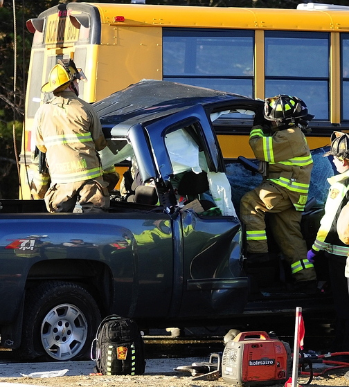 Emergency crews remove the roof of a pickup truck as they work to free the driver at the scene of a crash involving an Augusta school bus Tuesday on Riverside Drive just south of Stevens Road in Augusta.