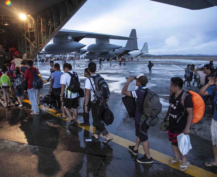 Civilians displaced by Typhoon Haiyan board a U.S. Marine Corps transport plane at Tacloban Air Base in Tacloban, Philippines, before being flown to Manila on Wednesday.