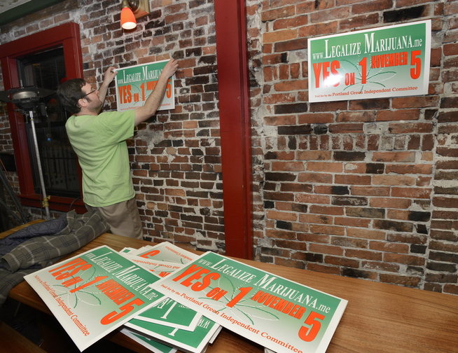 Yes on 1 campaign manager Tony Zeli hangs posters inside Brian Boru where they plan to celebrate a win.