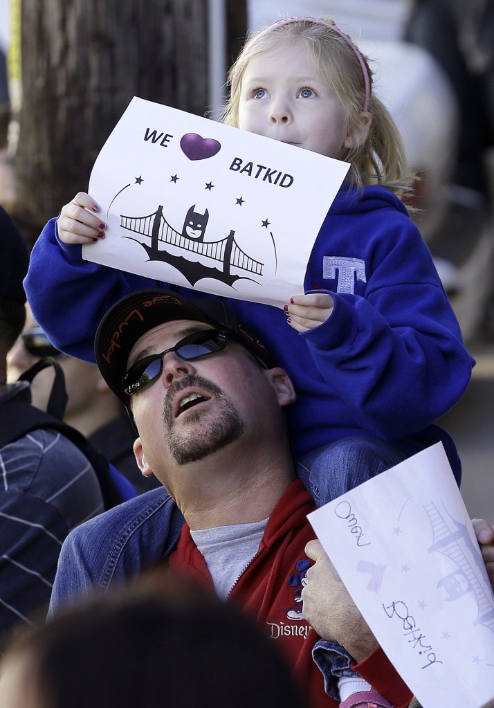 Daniel Fry holds up his daughter Kayla, 5, as they wait for Miles Scott, dressed as Batkid, in San Francisco.